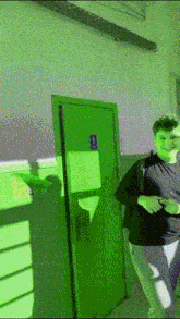a person standing in front of a green door with a sign on it that says ' no smoking '