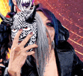 a woman with purple hair is wearing a mask with horns on it
