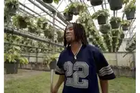 a man wearing a number 22 jersey stands in a greenhouse