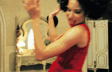 a woman in a red dress dancing in a room