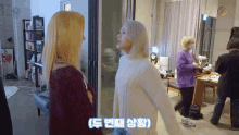 two women are standing next to each other in a room with a sign that says ' korean ' on it