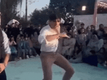 a man is dancing in front of a crowd of people at a wedding reception .