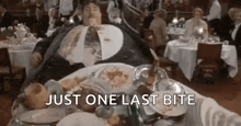 a fat man is laying on a table with a plate of food and the words `` just one last bite '' .