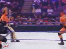 two wrestlers are fighting in a wrestling ring with a crowd watching