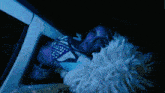 a cheerleader is laying in a car with a pom pom