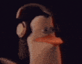 a close up of a penguin wearing headphones in the dark