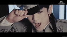a close up of a man wearing a hat with sm entertainment on the bottom