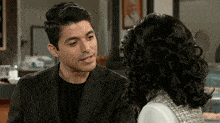 a man and a woman are looking at each other in a room