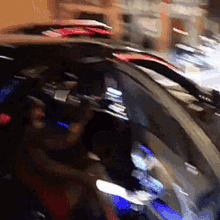 a blurry picture of a person sitting in a car with the hood open