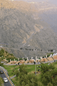 a white car is driving down a road in the middle of a mountain