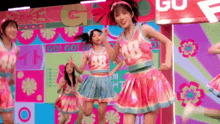 a group of girls are dancing on a stage and one of them has the number 48 on her jersey
