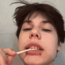 a close up of a person brushing their teeth with a toothbrush in their mouth .