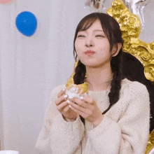 a woman giving a thumbs up while holding a sandwich
