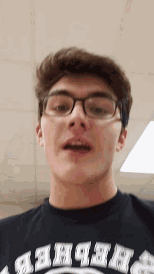 a young man wearing glasses and a shirt that says ' abercrombie ' on it