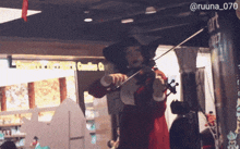 a man in a pirate costume is playing a violin in front of a sign that says candies