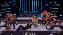 a group of wrestlers are fighting in a ring that says all elite aew on it