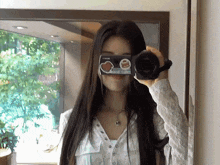 a woman is taking a picture of herself in a mirror with a sticker on her face that says " i love you "