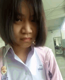 a girl wearing a white shirt and a pink jacket with ua on it