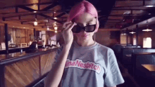 a woman with pink hair is wearing sunglasses and a t-shirt that says inanebitch