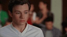 a young man in a white shirt has a crying look on his face