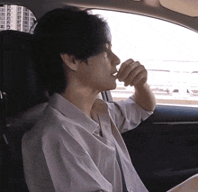 a man in a white shirt is sitting in the back seat of a car