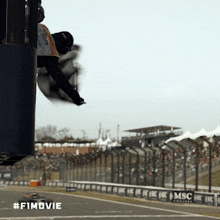 a man is flying through the air at a race track with the #f1movie written on the bottom