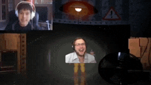 a man wearing headphones is laughing in front of a computer monitor