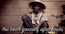 a man wearing a hat sits in front of a brick wall with the words " you touch yourself after hours "