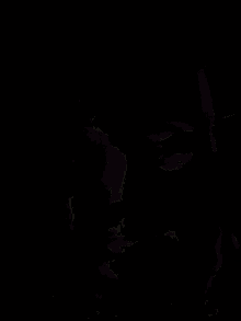 a close up of a person 's face with a green light behind them