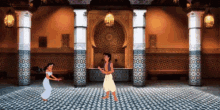 a man and a woman dancing in a room with columns