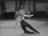 a black and white photo of a man dancing on the floor
