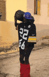 a man wearing a number 22 jersey holds a boombox