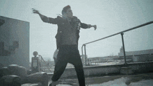 a man dancing on a rooftop with his arms outstretched