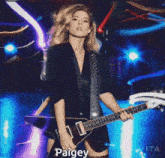 a picture of a woman holding a guitar with the name paigey at the bottom