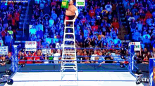 a wrestler is standing on a ladder in the middle of a wrestling ring .