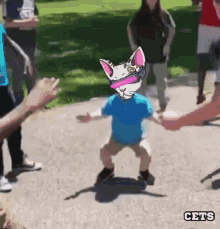 a person with a cat on their head is holding hands with a group of people
