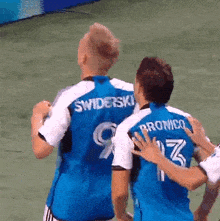 two soccer players are hugging each other and one has the number 13 on his jersey