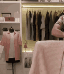 a woman is standing in front of a closet filled with clothes .