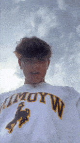a young man wearing a t-shirt with the word muyw on it