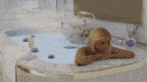 a woman laying in a bathtub with a glass of wine