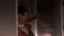 a man taking a shower with a bottle of vodka