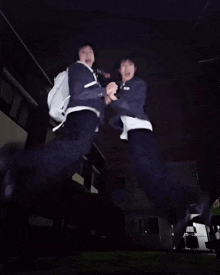 a couple of people jumping in the air with a backpack