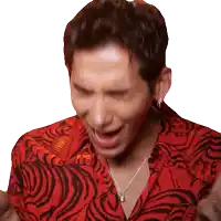 a man wearing a red shirt and a necklace is making a face