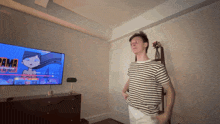 a man in a striped shirt stands in front of a flat screen tv that says pama