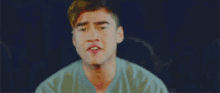 a young man is making a funny face while sitting in a chair .