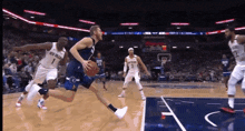 a basketball player wearing a new orleans uniform dribbles the ball