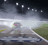 a race car is going around a curve on a track at night