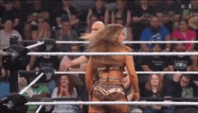 a woman in a wrestling ring is wearing a shirt that says nwo on it