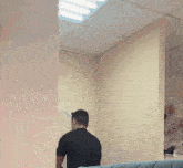 a man in a black shirt is looking at himself in the mirror