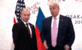 a man in a suit and tie is standing next to a man in a suit and tie .
